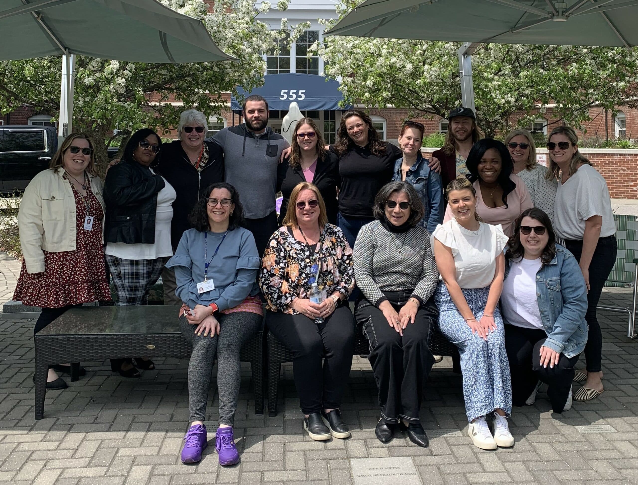 The pediatric palliative care team posing for a photo in front of a building.