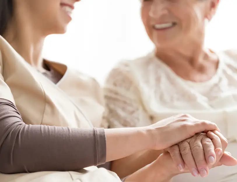 A nurse holding a patients hand