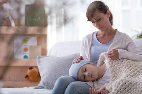 A child laying in a nurses lap