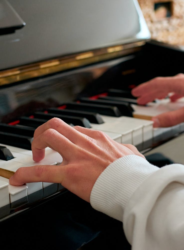 selective-focus-shot-hands-playing-piano