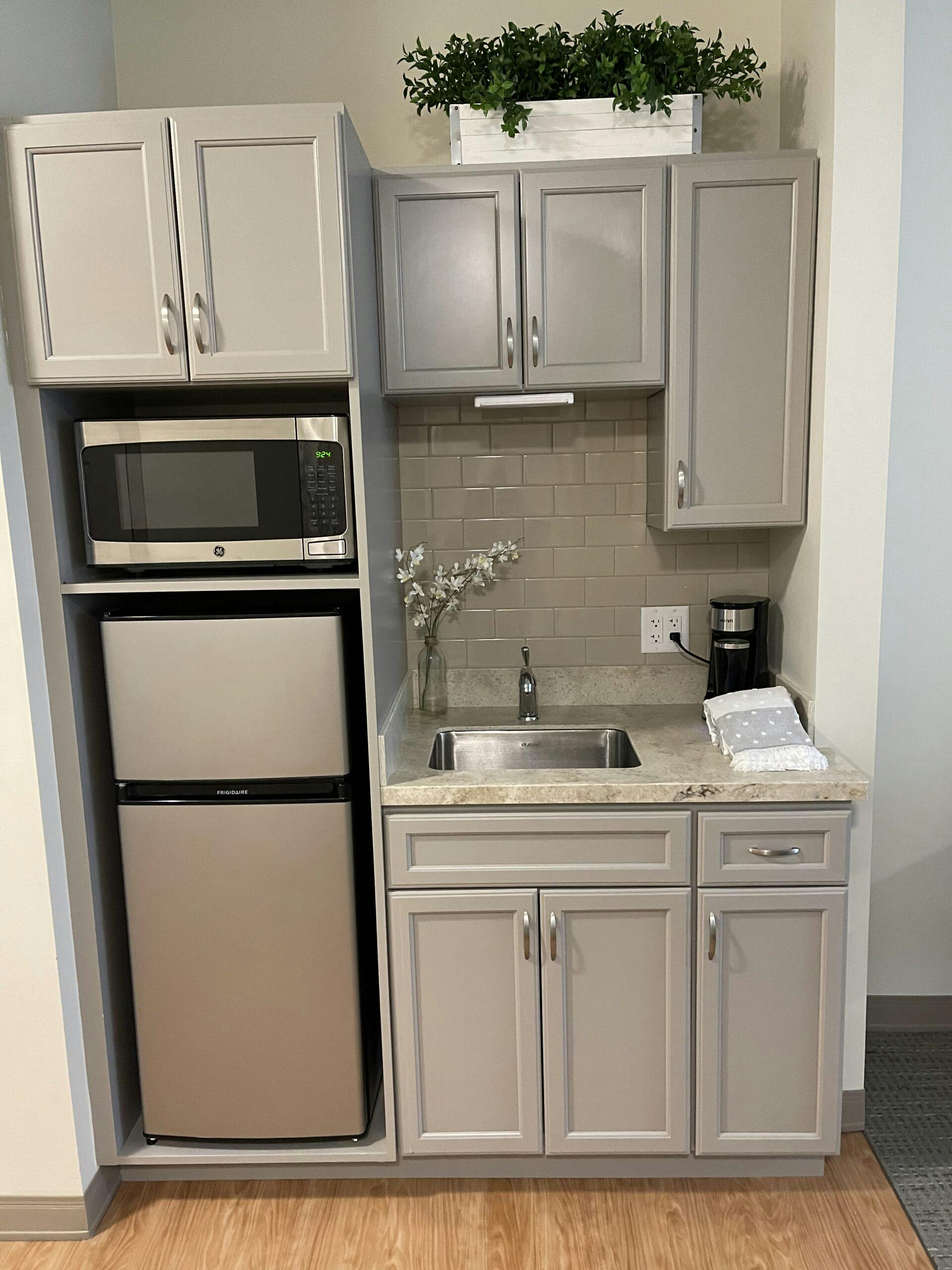 An assisted living kitchenette with a microwave and refrigerator.